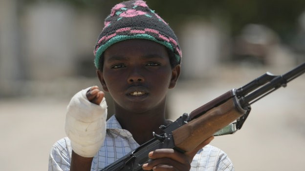 طفل صومالي مصاب ومسلح في صورة من الأرشيف