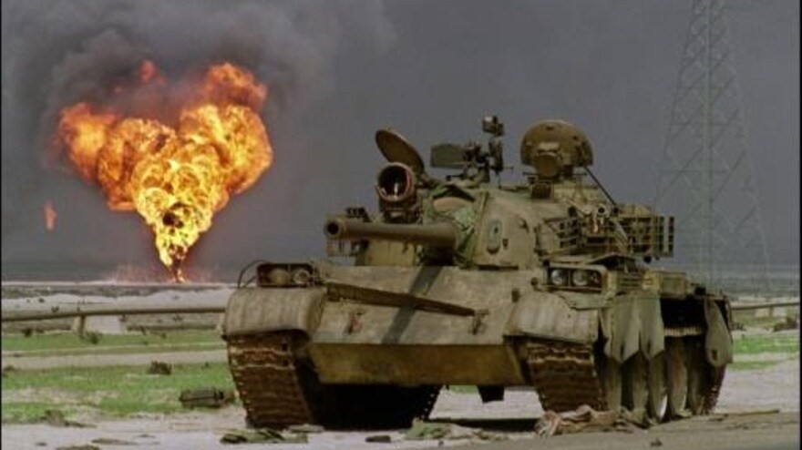  صورة من الارشيف لدبابة عراقية متروكة في الصحراء الكويتية ويبدو حقل نفط يحترق خلفها في 2 ابريل 1991