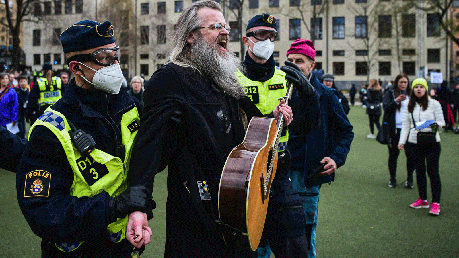 ضباط الشرطة يزيلون الناس أثناء تجمعهم للاحتجاج على قيود البلاد ضد فيروس كورونا في وسط ستوكهولم، السويد .1 أيار\مايو 2021