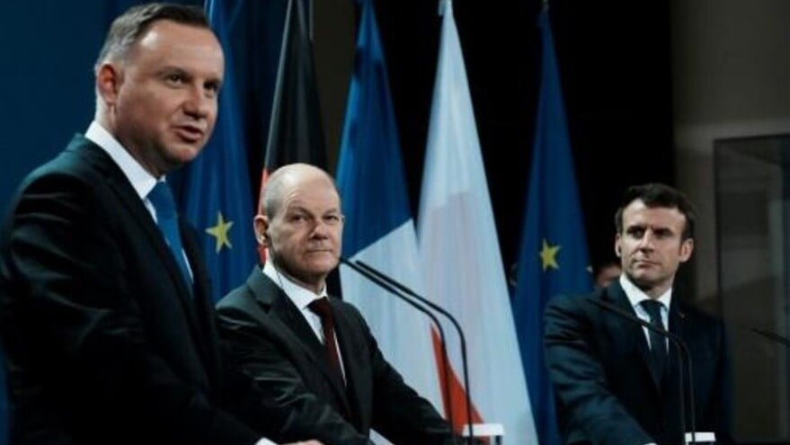  المستشار الألماني اولاف شولتس (وسط) إلى جانب الرئيس البولندي أندريه دودا (يسار) والفرنسي إيمانويل ماكرون في برلين بتاريخ 8 فبراير 2022 