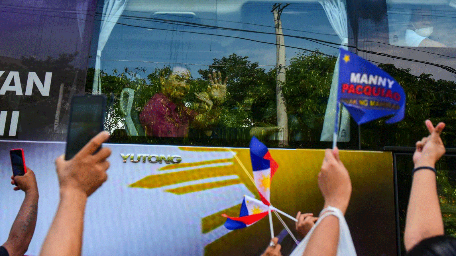 رمز الملاكمة والسناتور الفلبيني ماني باكياو يلوّح لأنصاره عند وصوله في حافلة لتقديم شهادة ترشيحه لرئاسة الفيلبين في مانيلا في الأول تشرين الأول/ أكتوبر 2021