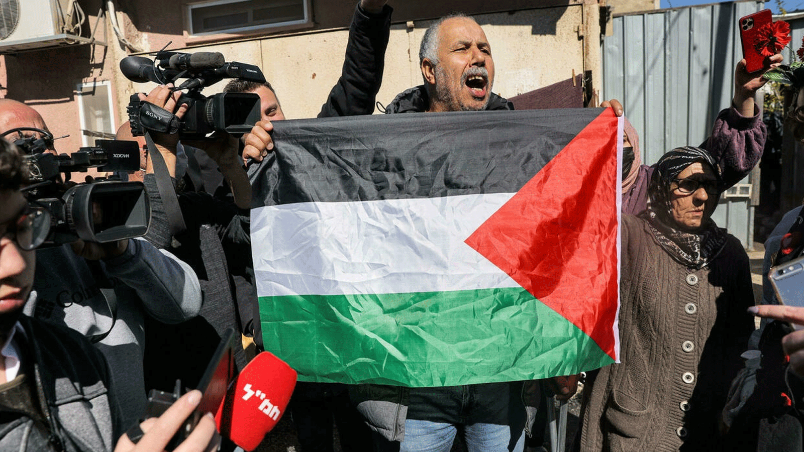 رجل فلسطيني يحمل العلم أثناء مواجهته للمستوطنين اليهود الإسرائيليين في حي الشيخ جراح بالقدس الشرقية في 13 شباط\ فبراير 2022
