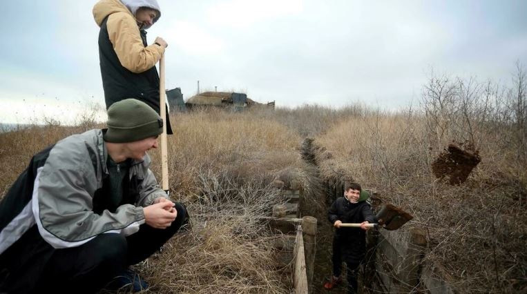 مراهقون أوكرانيون يحفرون الخنادق للجنود الذين يخدمون في الجبهة الشرقية لبلادهم