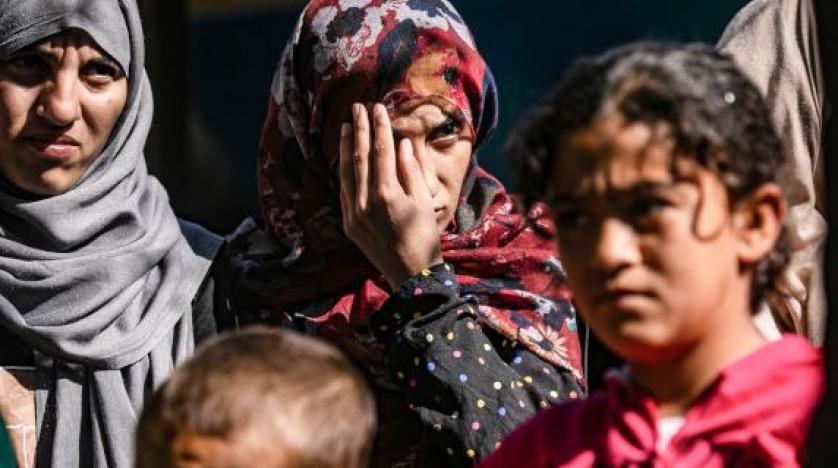 نساء وأطفال إيزيديون عراقيون تم إنقاذهم من تنظيم داعش في انتظار ركوب حافلات متجهة إلى سنجار في قلب اليزيديين بالعراق