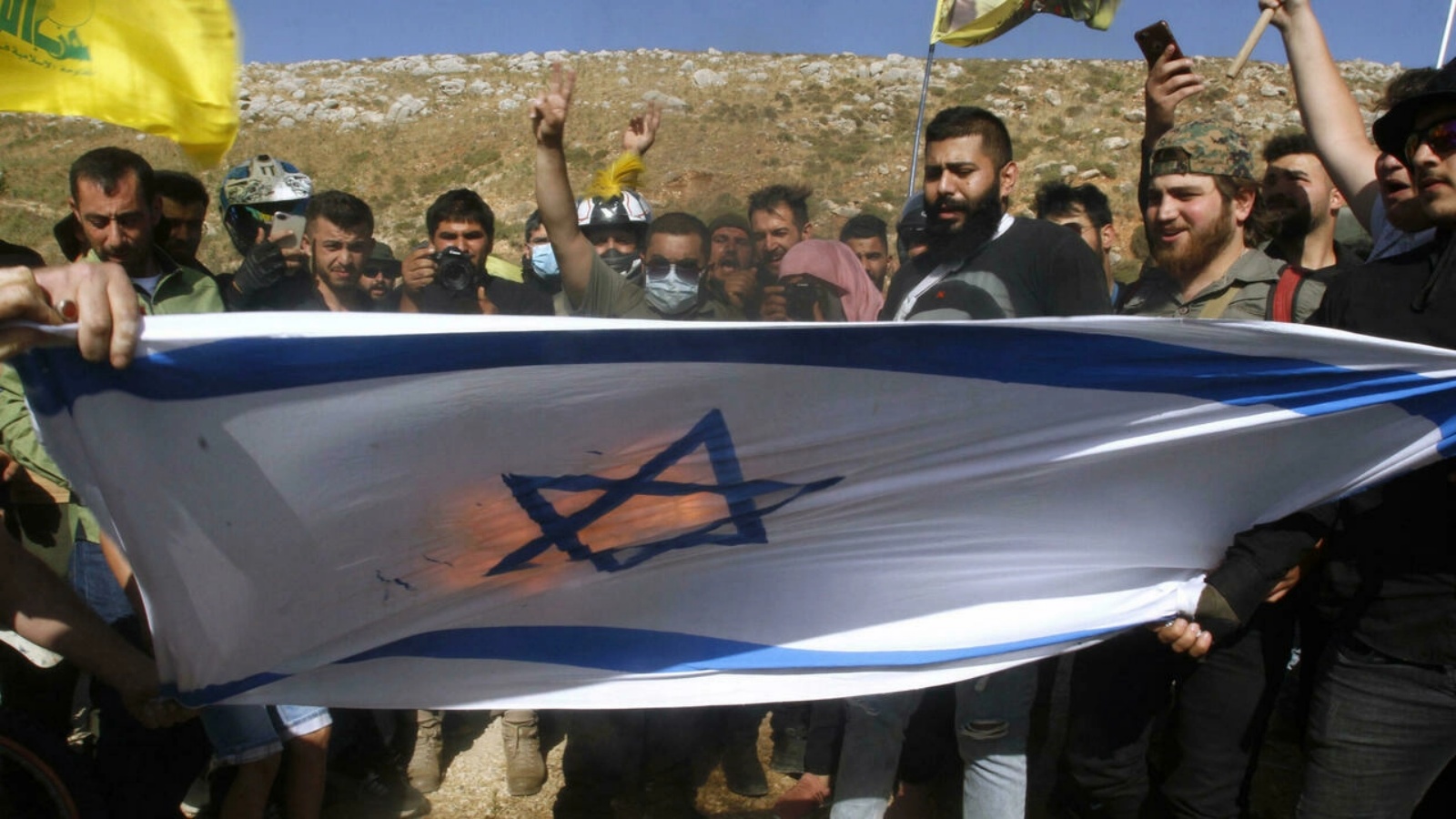 أنصار حزب الله يحرقون العلم الإسرائيلي في منطقة الخيام الحدودية في جنوب لبنان بتاريخ 25 مايو 2021