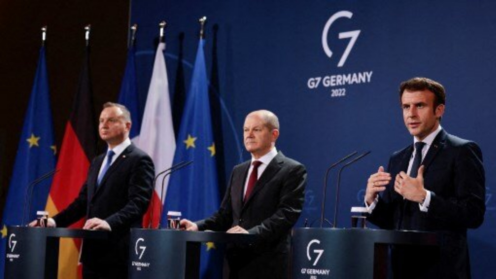 الرئيس الفرنسي إيمانويل ماكرون (يمين) يتحدث خلال مؤتمر صحفي مشترك مع الرئيس البولندي أندريه دودا (يسار) والمستشار الألماني أولاف شولتس (وسط) قبل اجتماع مثلث فايمار في المستشارية في برلين، في 8 فبراير 2022.