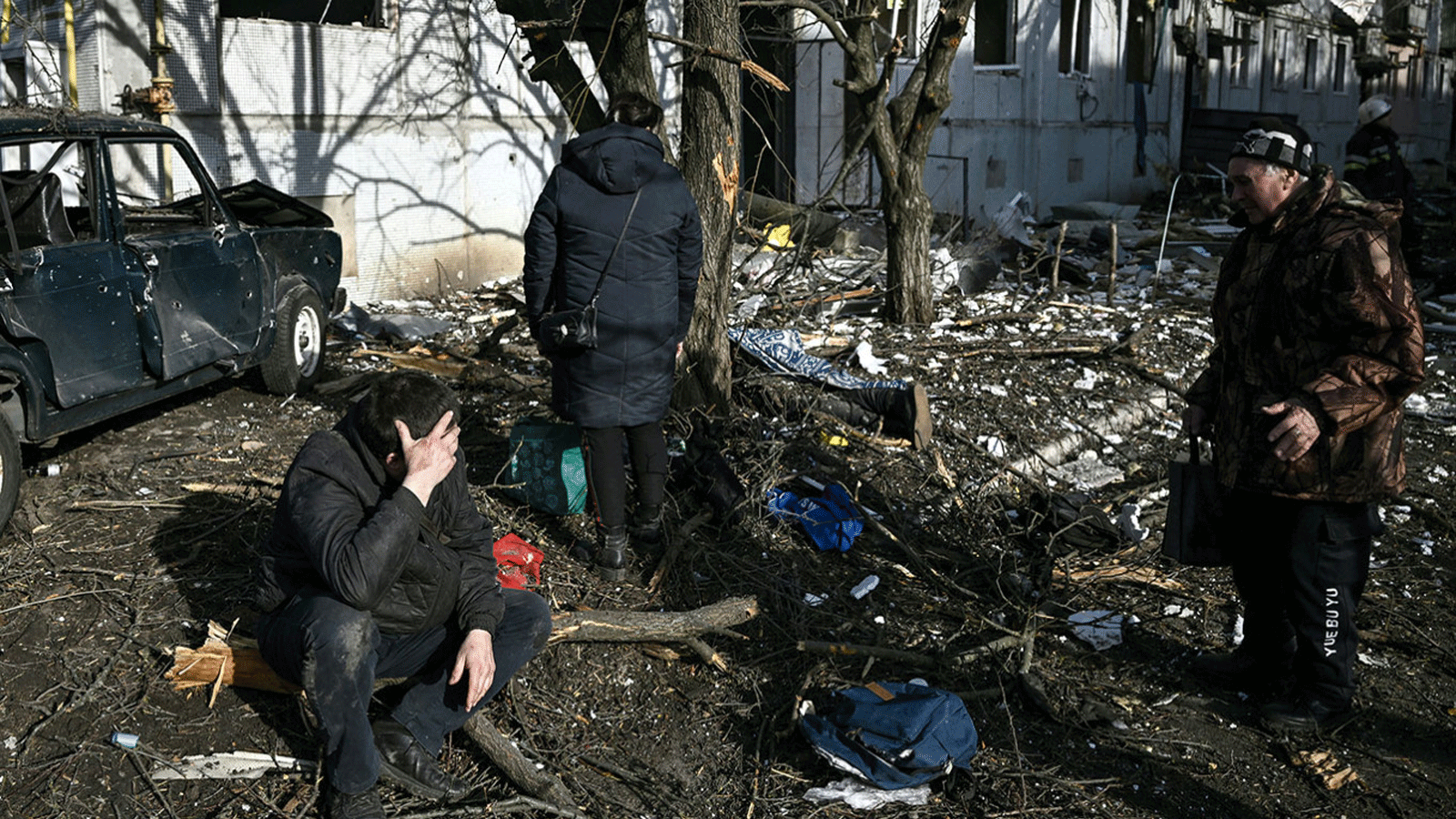 أشخاص يراقبون مخلفات القصف في بلدة تشوغويف بشرق أوكرانيا في 24 شباط\ فبراير 2022.