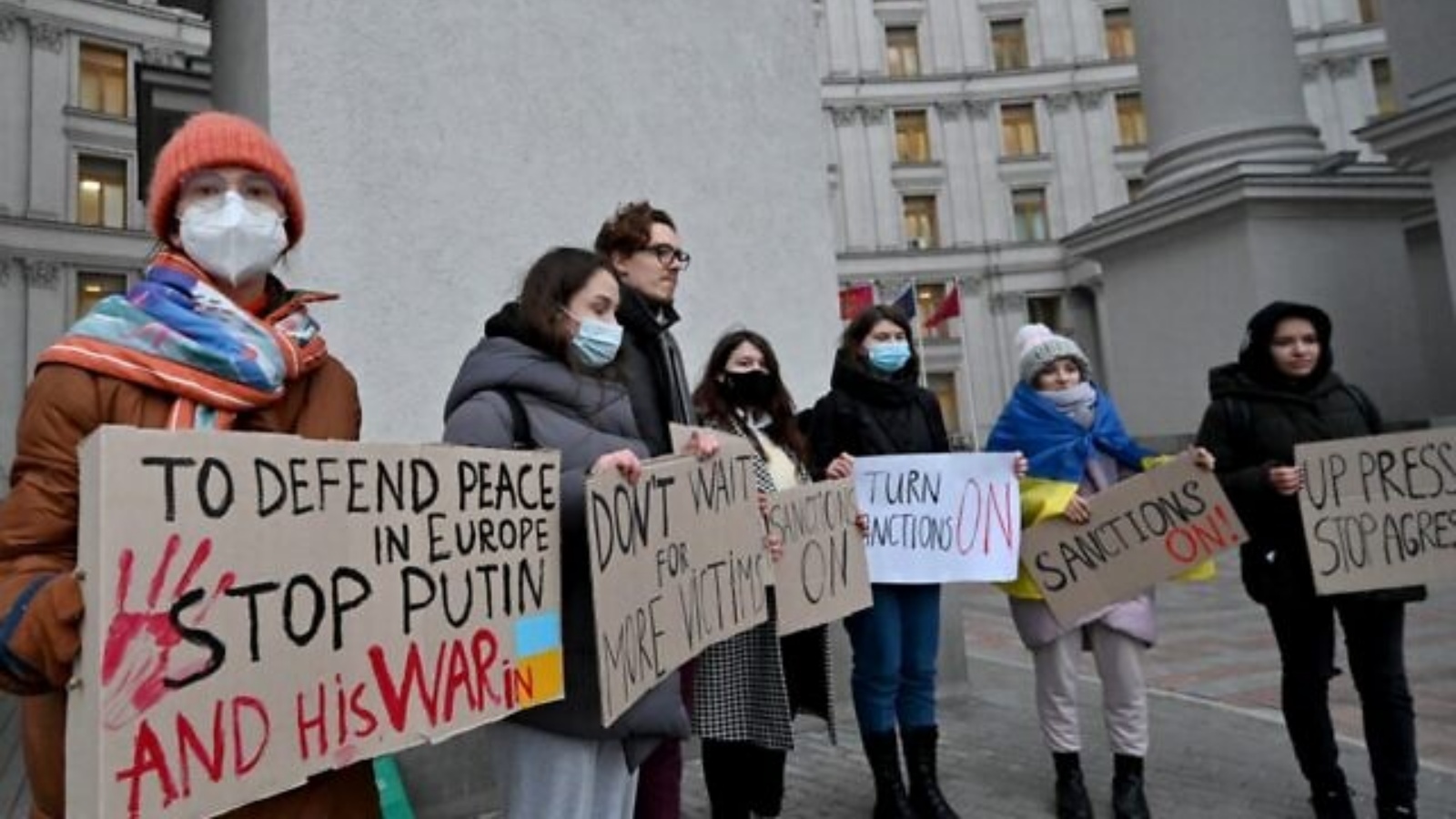 متظاهرون يحملون لافتات تطالب بفرض عقوبات خلال مسيرة خارج وزارة الخارجية الأوكرانية في كييف في 21 فبراير 2022