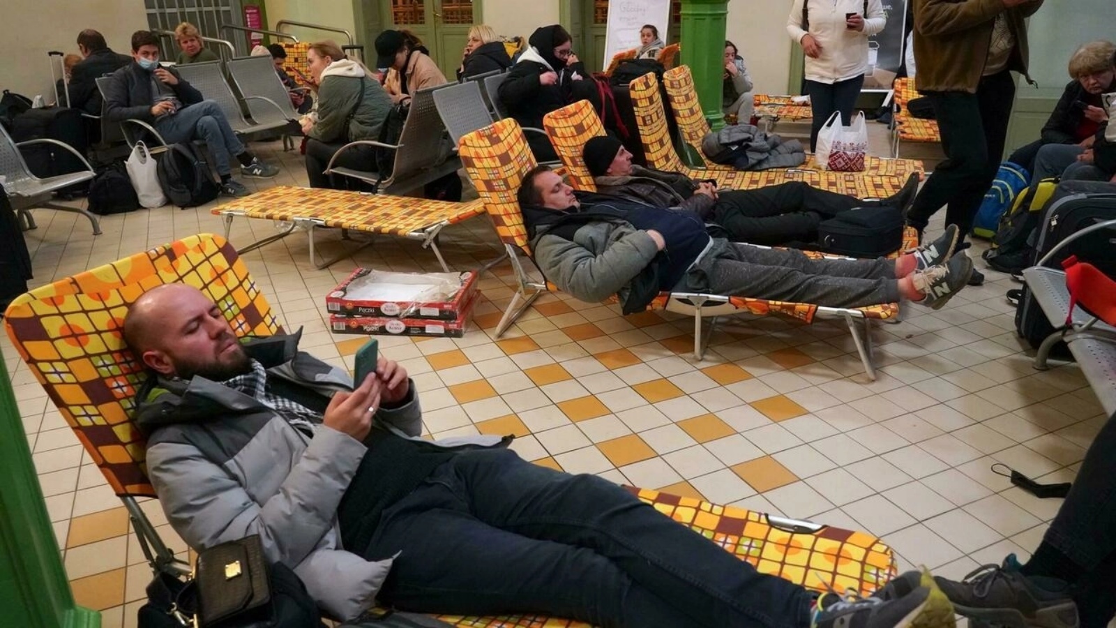 أوكرانيون ينتظرون في محطة القطارات في شيهموشيل ببولندا بالقرب من الحدود الأوكرانية في 24 فبراير 2022 بعد فرارهم من أوكرانيا