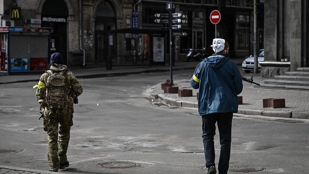 جندي ومدني أوكرانيان في دورية في مدينة كييف بحثاً عن عملاء روسيا في 27 فبراير 2022 