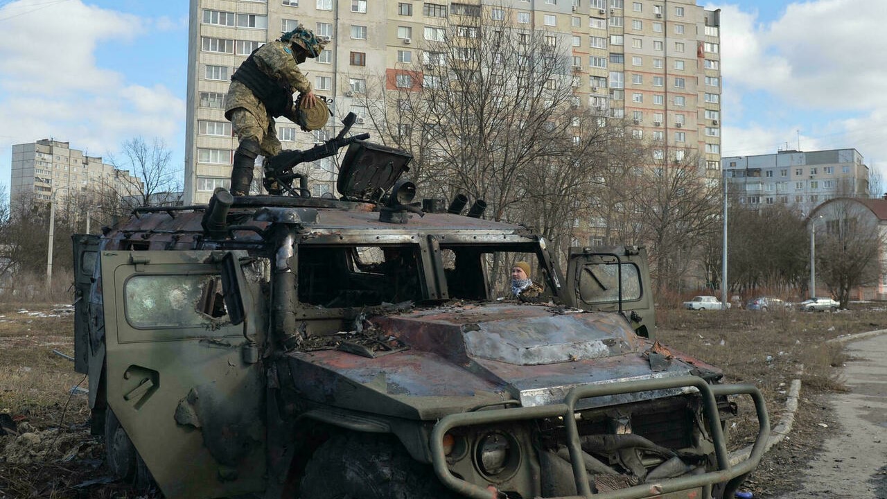 مقاتل أوكراني يتفحص عربة روسية تم تدميرها أثناء المعارك في مدينة خاركيف، 27 فبراير 2022