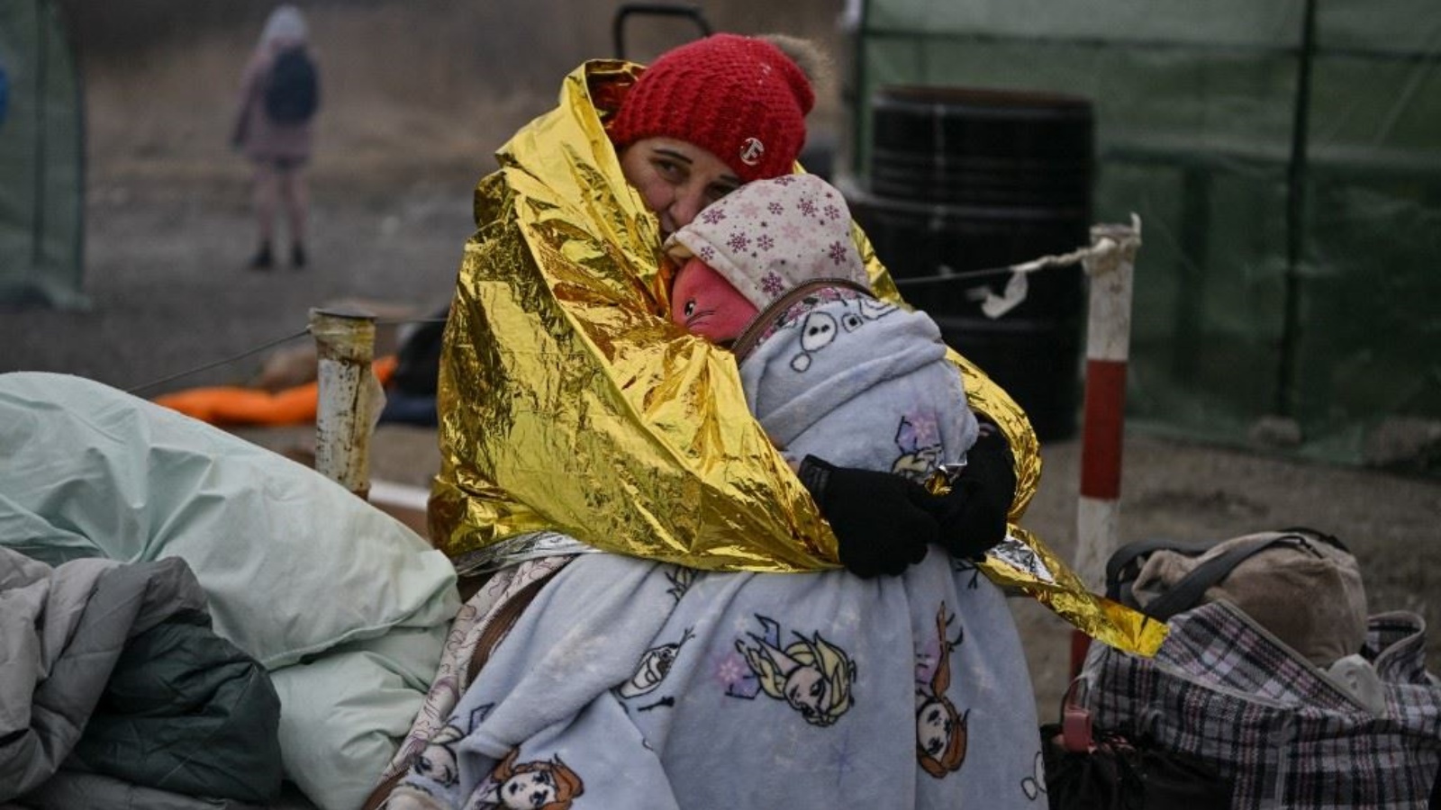 نازحة أوكرانية مع طفلها على الحدود مع بولندا