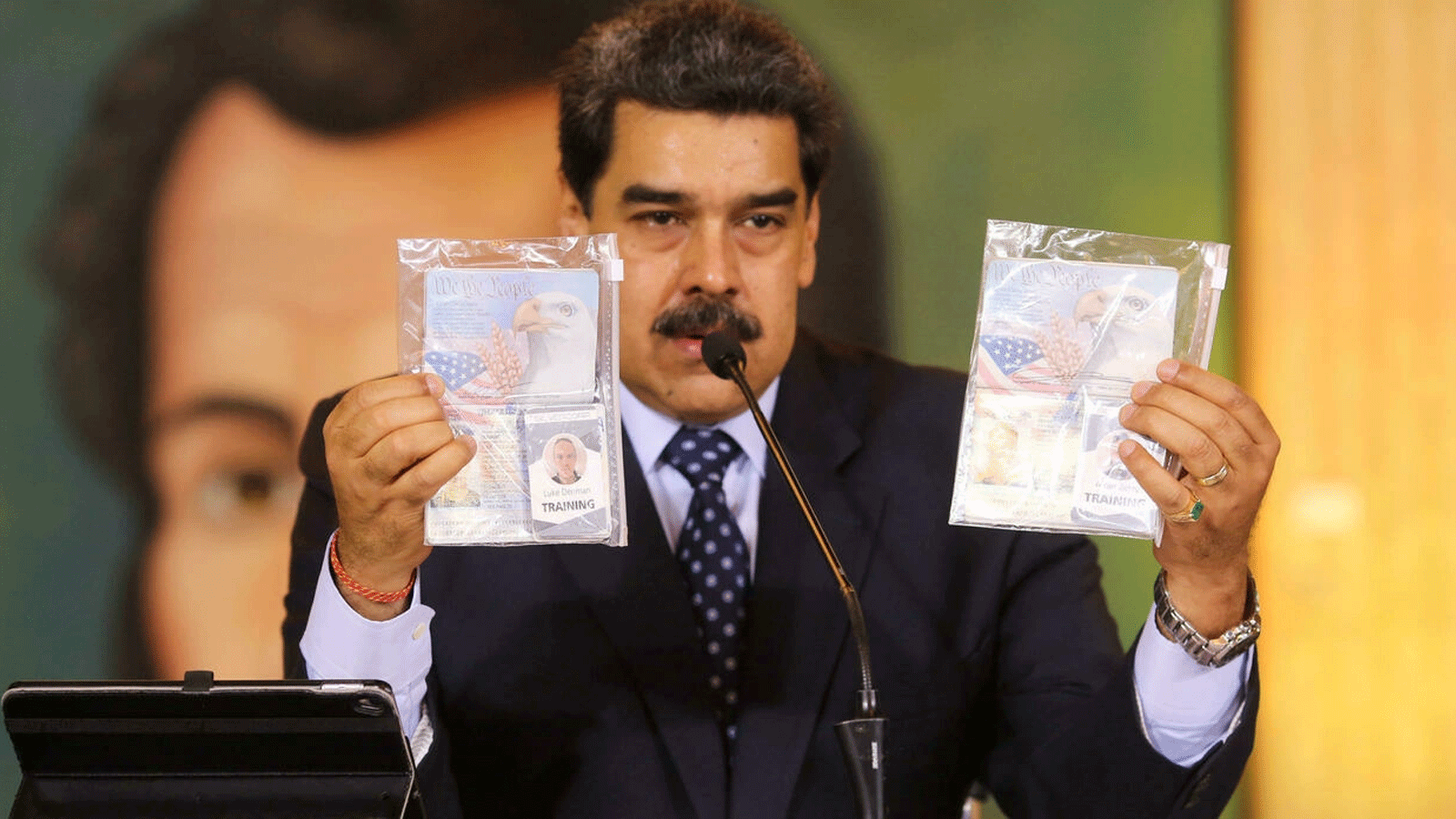 نيكولاس مادورو يُمسك جوازي سفر مواطنين أمريكيين اعتقلتهما قوات الأمن، خلال مؤتمر بالفيديو مع وسائل إعلام دولية، في قصر ميرافلوريس الرئاسي في كاراكاس. 6 أيار\مايو 2020.