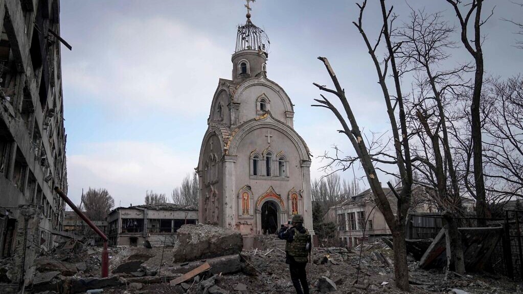 جندي أوكراني يلتقط صورة لكنيسة مدمرة بعد قصف حي سكني في ماريوبول، أوكرانيا، 10 مارس 2022
