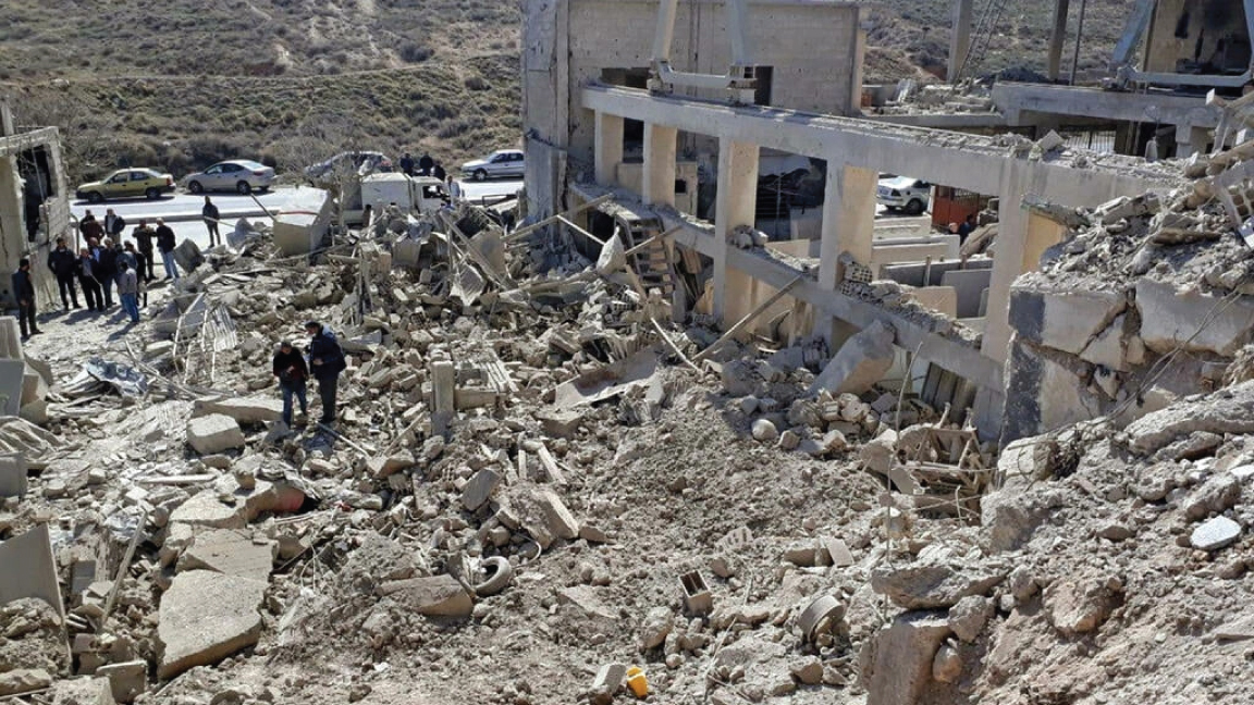 مواطنون يتفقدون المباني المدمرة والمتضررة إثر ضربات صاروخية إسرائيلية قرب العاصمة السورية دمشق في 7 مارس 2022