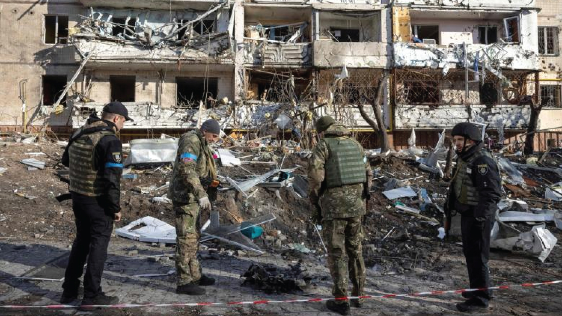 جنود أوكرانيون يتفقدون أنقاض مبنى سكني مدمر في كييف ، أوكرانيا ، في 15 مارس 2022