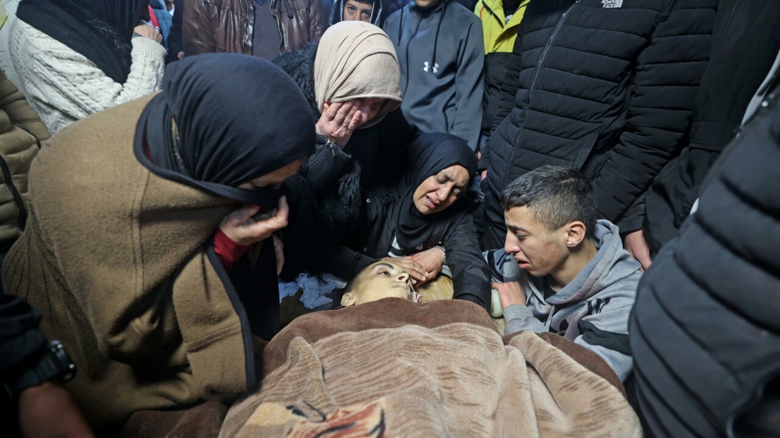 أقارب الفتى الفلسطيني نادر ريان أمام جثته في مستشفى في نابلس بتاريخ 15 مارس 2022