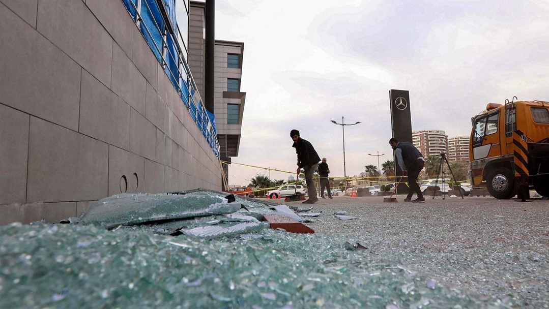 مواطنون أكراد يزيلون الأضرار من إحدى المنشآت التجارية التي تضررت بفعل سقوط الصواريخ الإيرانية على إربيل