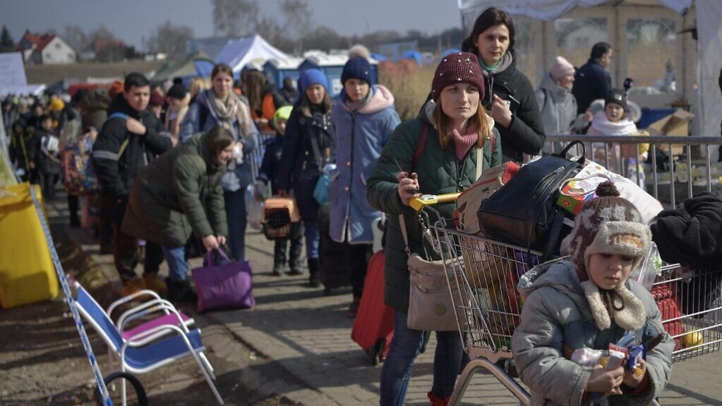 أوكرانيون يسيرون ساعات لعبور الحدود الأوكرانية إلى بولندا في ميديكا، في 13 مارس 2022