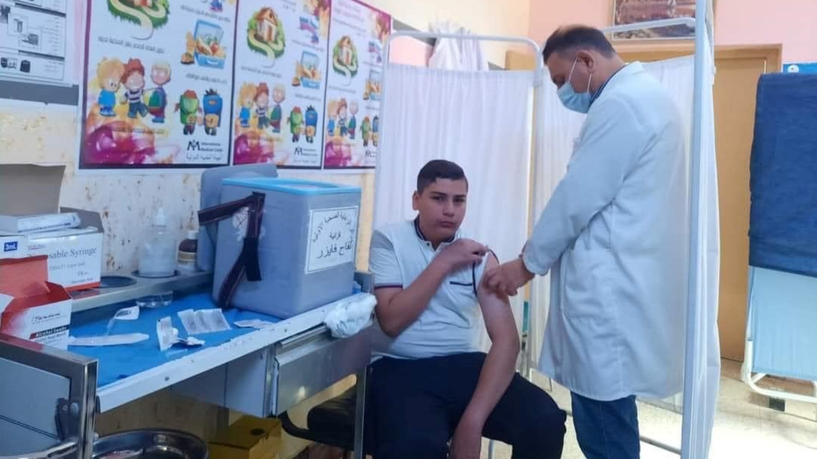 فتى عراقي يتلقى اللقاح المضاد لفايروس كورونا في أحد المراكز الصحية (الوزارة)