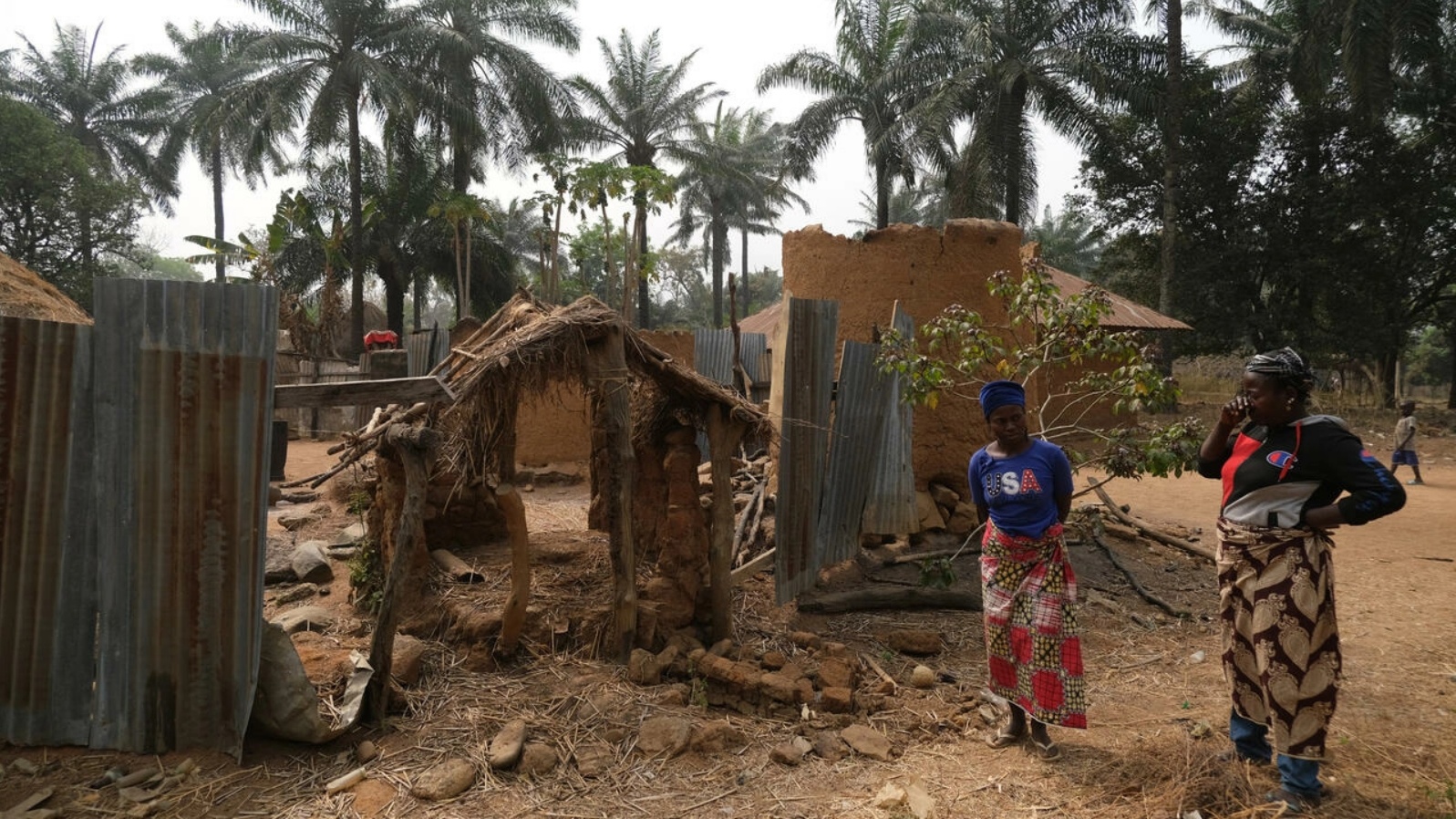 سكان أمام منازلهم المدمرة في قرية مانغا في نيجيريا في 28 يناير 2022 