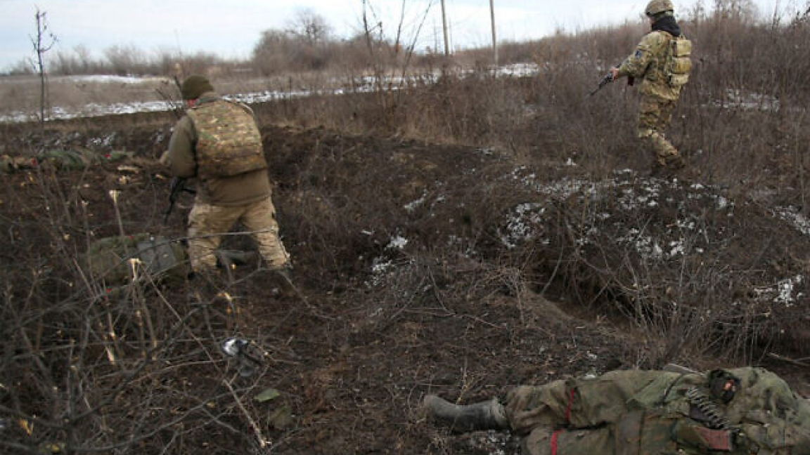 القوات الأوكرانية تسير بجوار جثة، بعد القتال ضد القوات الروسية والانفصاليين المدعومين من روسيا بالقرب من قرية زولوتي، منطقة لوغانسك، 6 مارس 2022