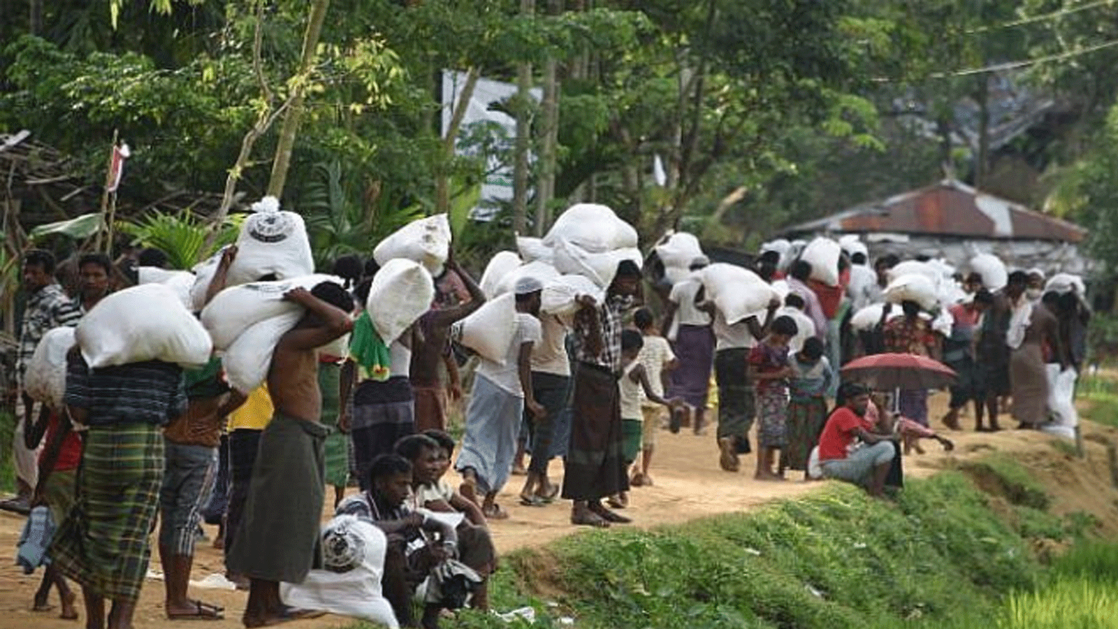 اللاجئون المسلمون من الروهينغا يحملون الطعام الموزع في مركز بالوخالي بالقرب من جومدهوم في بنغلاديش في 26 أيلول\سبتمبر 2017