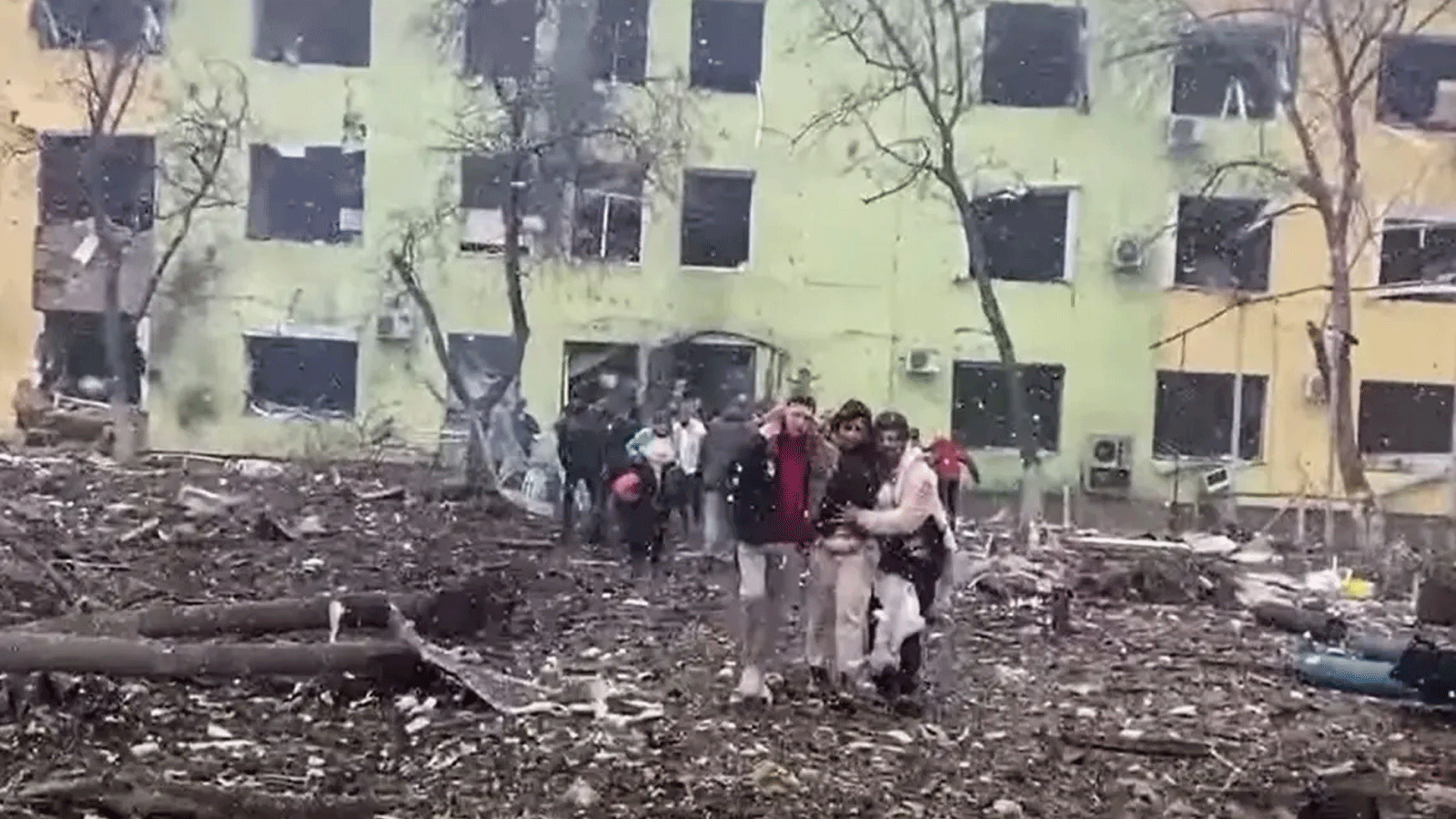  صورة من مقطع مصور التقطته الشرطة الوطنية الأوكرانية ونشرته في 9 آذار\مارس 2022 خلال مساعدة الناس على الخروج من مبنى متضرر بمستشفى للأطفال في أعقاب غارة جوية روسية على مدينة ماريوبول الجنوبية الشرقية