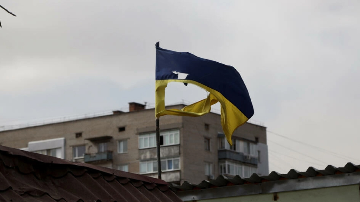 علم أوكراني ممزق مرفوع فوق مبنى في ميكولاييف بجنوب أوكرانيا في 27 مارس 2022