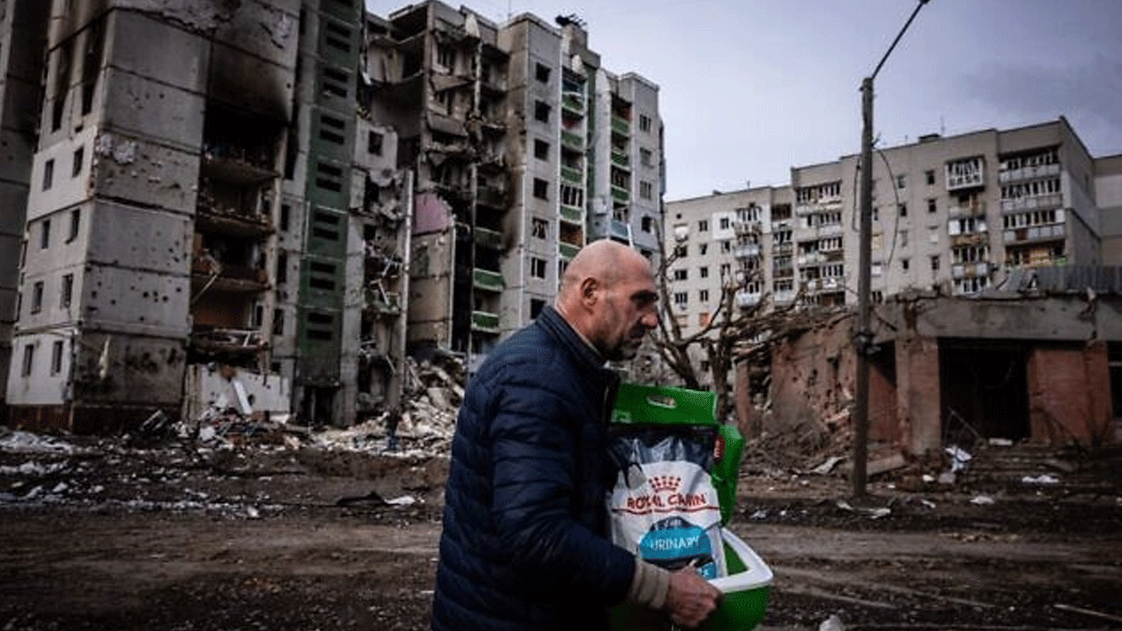 رجل يسير أمام مبنى سكني تضرر من القصف على مدينة تشيرنيهيف