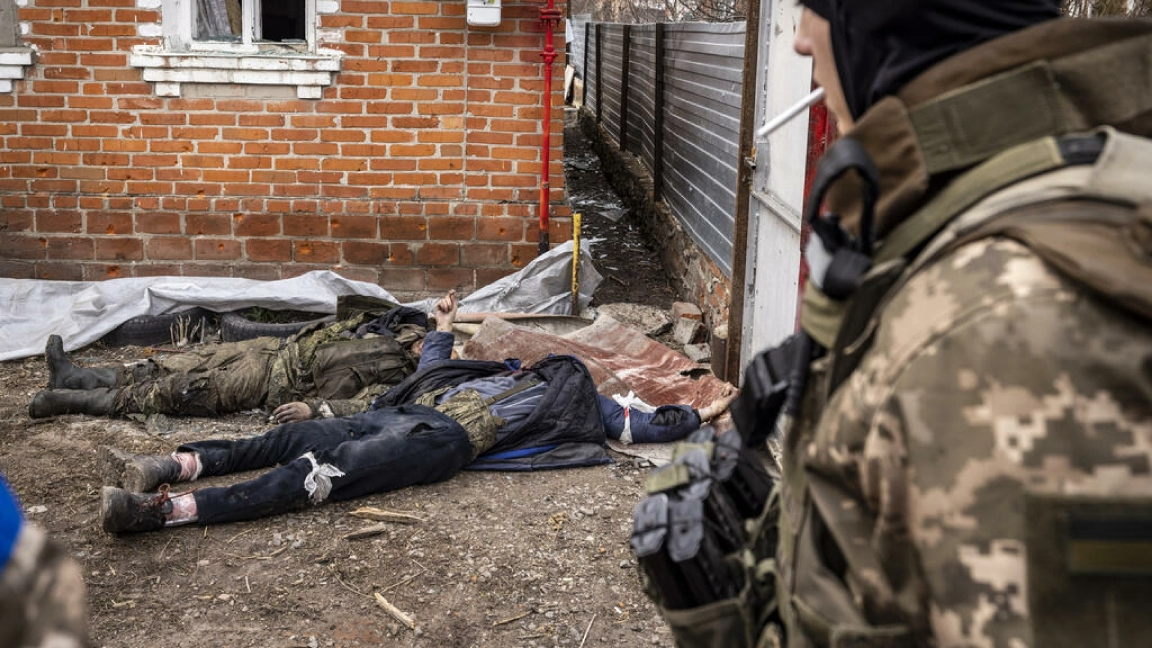 جندي أوكراني يمرّ قرب جثث جنود روس بعد استعادة القوات الأوكرانية لقرية مالا روغان في شرق مدينة خاركيف الأوكرانية في 30 مارس 2022