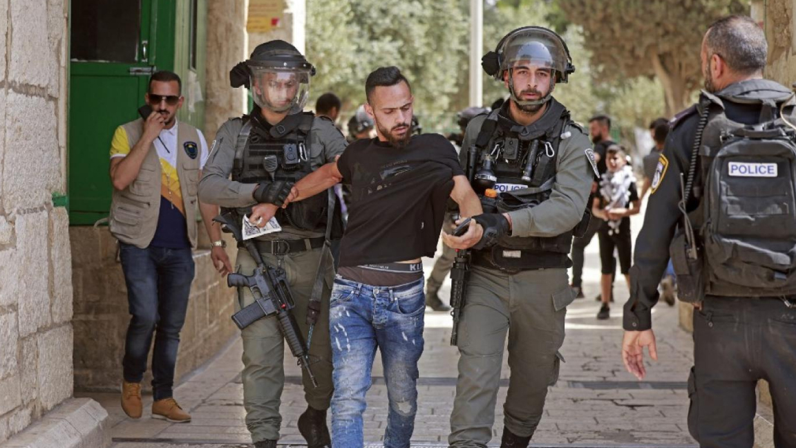قوات الأمن الإسرائيلية تعتقل رجلاً عند مدخل المسجد الأقصى بالقدس، في 21 مايو 2021