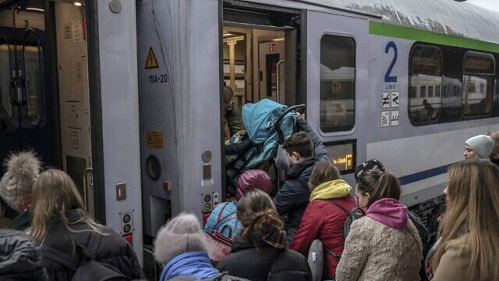 لاجئون من أوكرانيا يستقلون قطارًا في طريقهم إلى وارسو في محطة السكك الحديدية في برزيميسل، جنوب شرق بولندا، بالقرب من الحدود البولندية الأوكرانية في نيسان\ أبريل 2022.