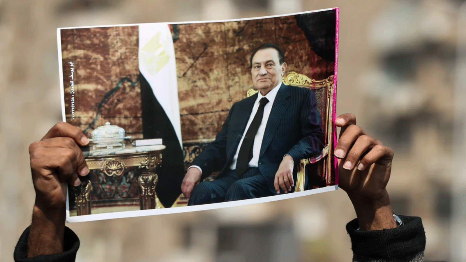أحد مؤيدي الرئيس المصري الأسبق حسني مبارك يرفع صورة للزعيم الراحل بالقرب من مقبرة العائلة حيث سيدفن في حي مصر الجديدة بالعاصمة القاهرة يوم 26 شباط\ فبراير 2020