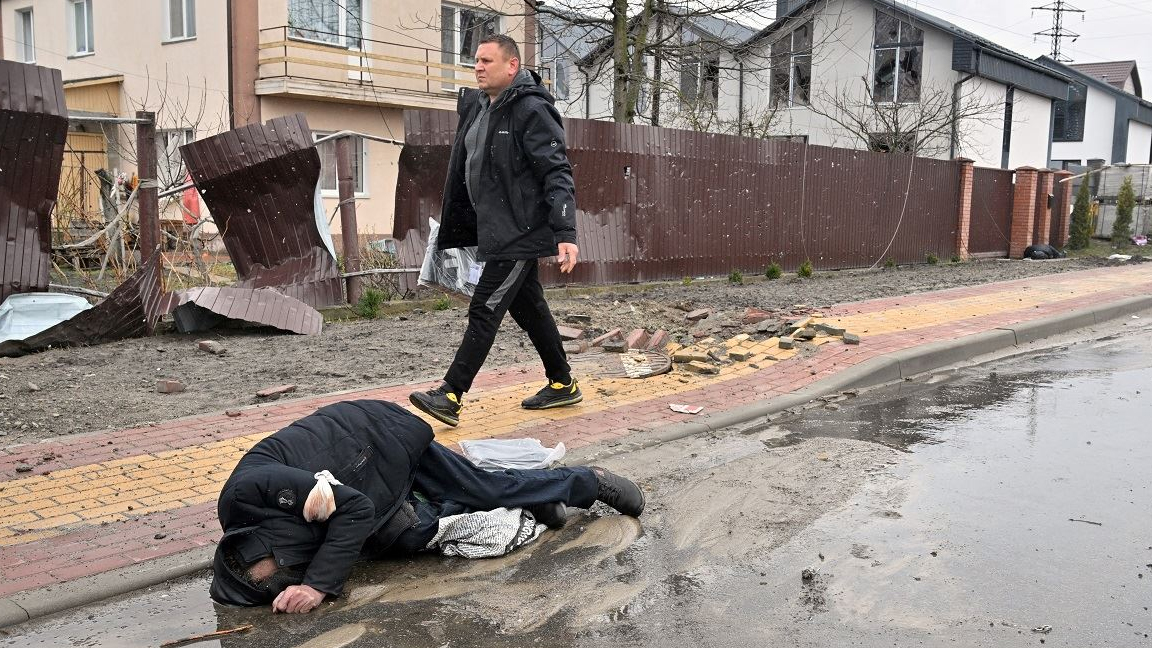 رجل يمر بجانب جثة مدنية في بلدة بوتشا، ليست بعيدة عن العاصمة الأوكرانية كييف في 3 أبريل 2022