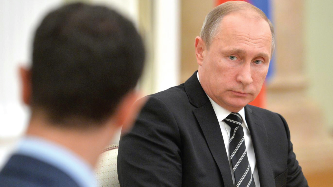 الرئيس الروسي فلاديمير بوتين ويبدو من الخلف رئيس النظام السوري بشار الأسد