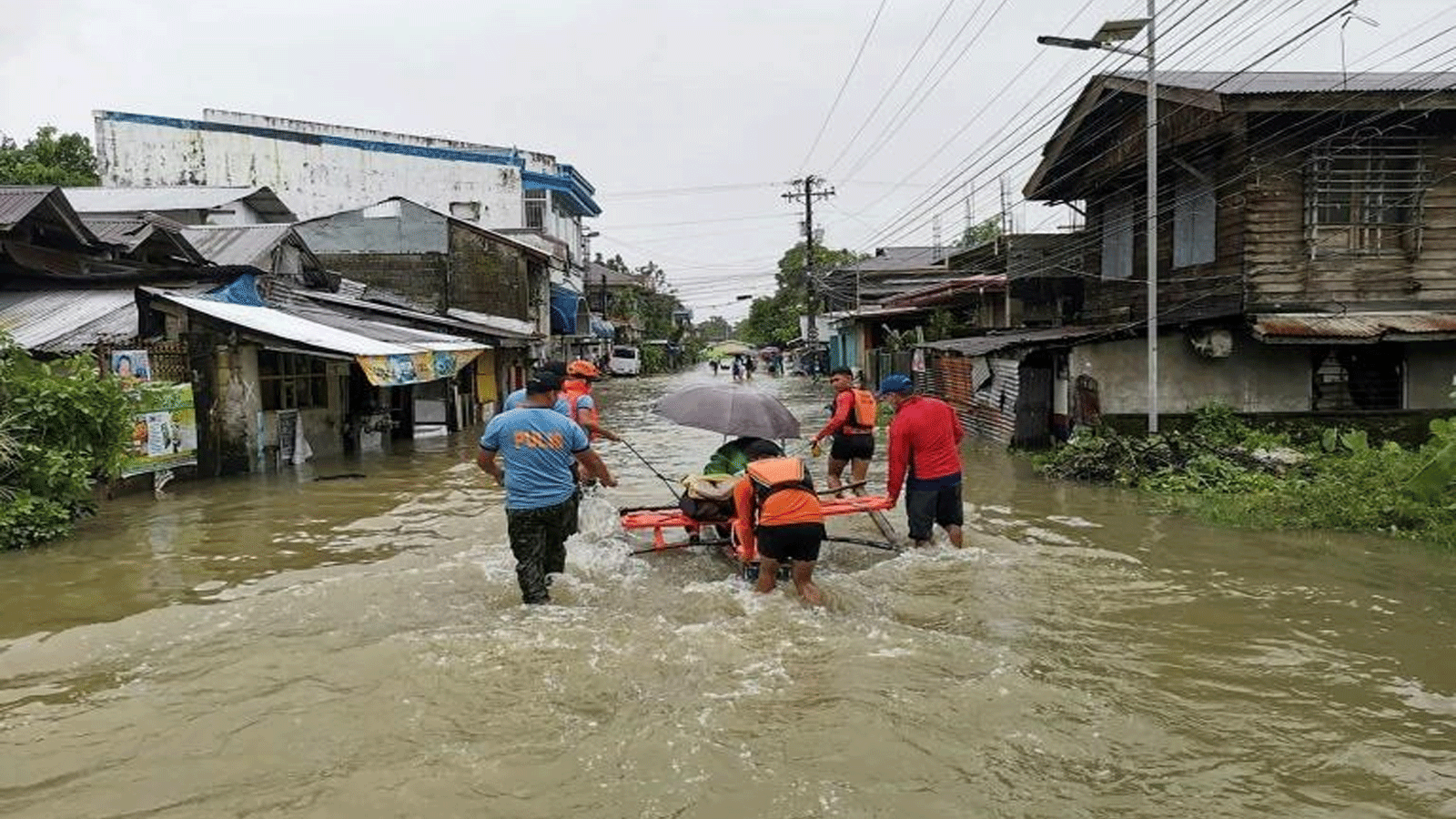 عمال الإنقاذ يساعدون مواطنين أعاقهم الطين والأمطار خلال البحث عن ناجين من الانهيارات الأرضية التي اجتاحت قرى في وسط الفلبين