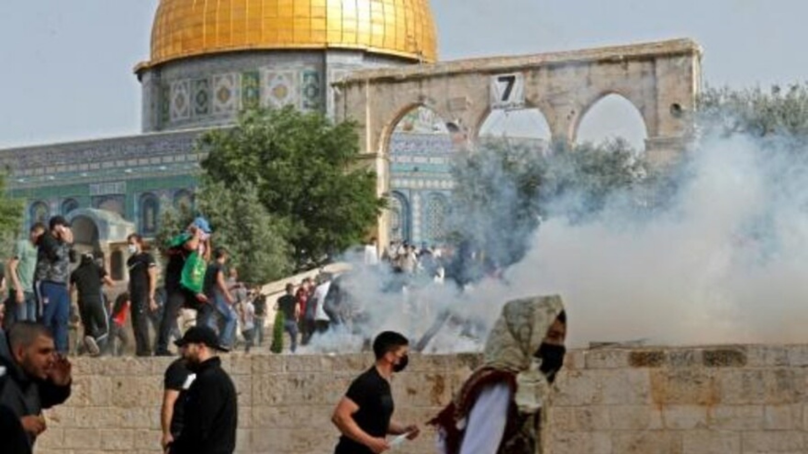 متظاهرون فلسطينيون يهربون من قنابل الغاز المسيل للدموع الذي أطلقته القوات الإسرائيلية خلال الاشتباكات الدائرة في باحات المسجد الأقصى في القدس الشرقية المحتلة في العاشر من مايو 2021 