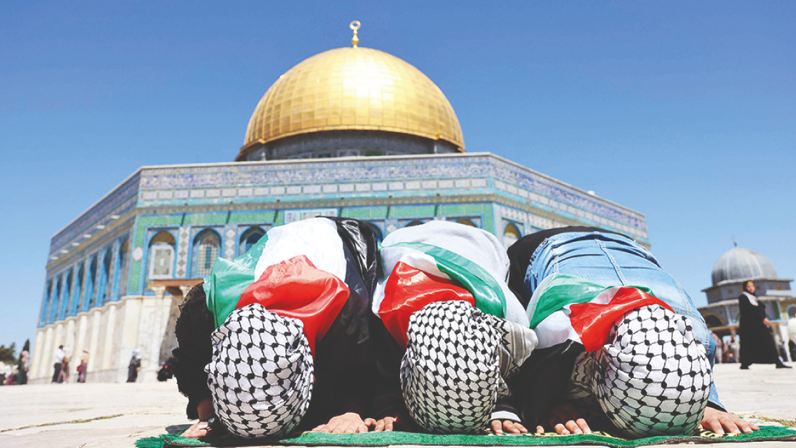 فتيات فلسطينيات يرتدين الأعلام الوطنية وأغطية رأس ذات مربعات 