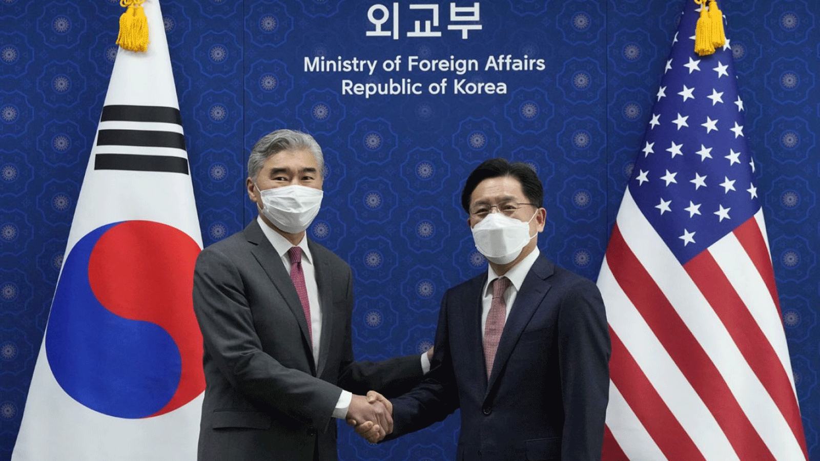 الممثل الأميريكي الخاص لكوريا الشمالية سونغ كيم (يسار) يصافح الممثل الخاص لكوريا الجنوبية لشؤون السلام والأمن في شبه الجزيرة الكورية نوه كيو دوك (يمين) خلال اجتماعهما في وزارة الخارجية في سيول في 18 نيسان\أبريل 2022.
