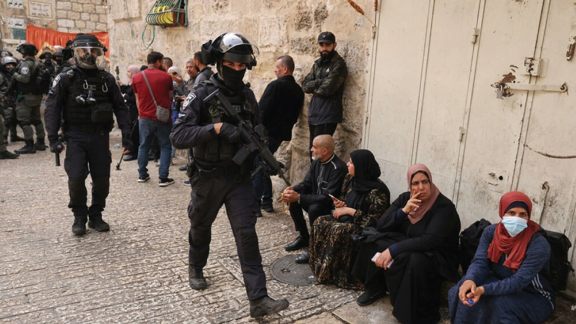 فلسطينيون ينتظرون السماح لهم بالدخول إلى باحات المسجد الأقصة في 17 نيسان/أبريل 2022 خلال دورية لقوات إسرائيلية بالقرب من باب الأسباط المؤدي إلى البلدة القديمة في القدس الشرقية المحتلة
