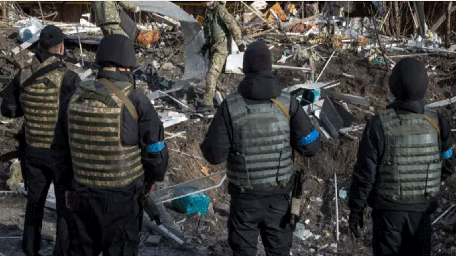 جنود أوكرانيون يتفقدون أنقاض مبنى سكني مدمر في كييف في 15 مارس / آذار 2022