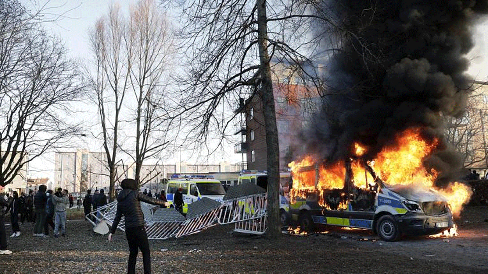 اشتعلت النيران في شاحنات الشرطة بينما كان رد فعل المتظاهرين المعارضين خلال احتجاج مضاد في حديقة Sveaparken في Orebro، جنوب وسط السويد في 15 نيسان\أبريل 2022