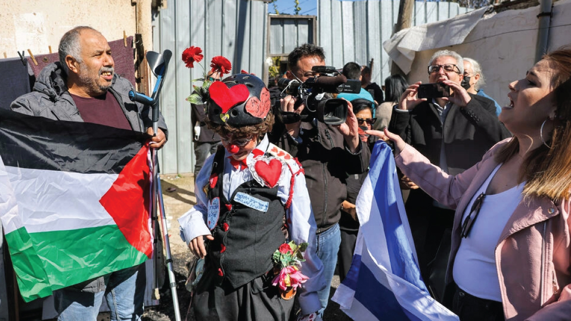 مواجهة بين رجل يحمل العلم الفلسطيني ومستوطنة تحمل العلم الإسرائيلي في حي الشيخ جراح في القدس الشرقية المحتلة في 13 فبراير 2022
