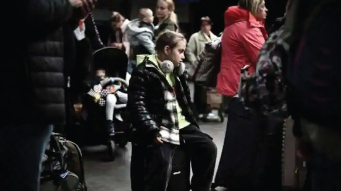 لاجئة أوكرانية شابة تجلس على حقيبتها بعد نزولها من مولدوفا في مطار بوردو الدولي في ميرينياك