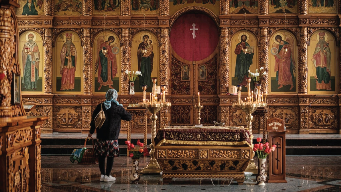 امرأة تصلي في كنيسة القيامة في سلوفيانسيك بشرق أوكرانيا في 23 أبريل 2022