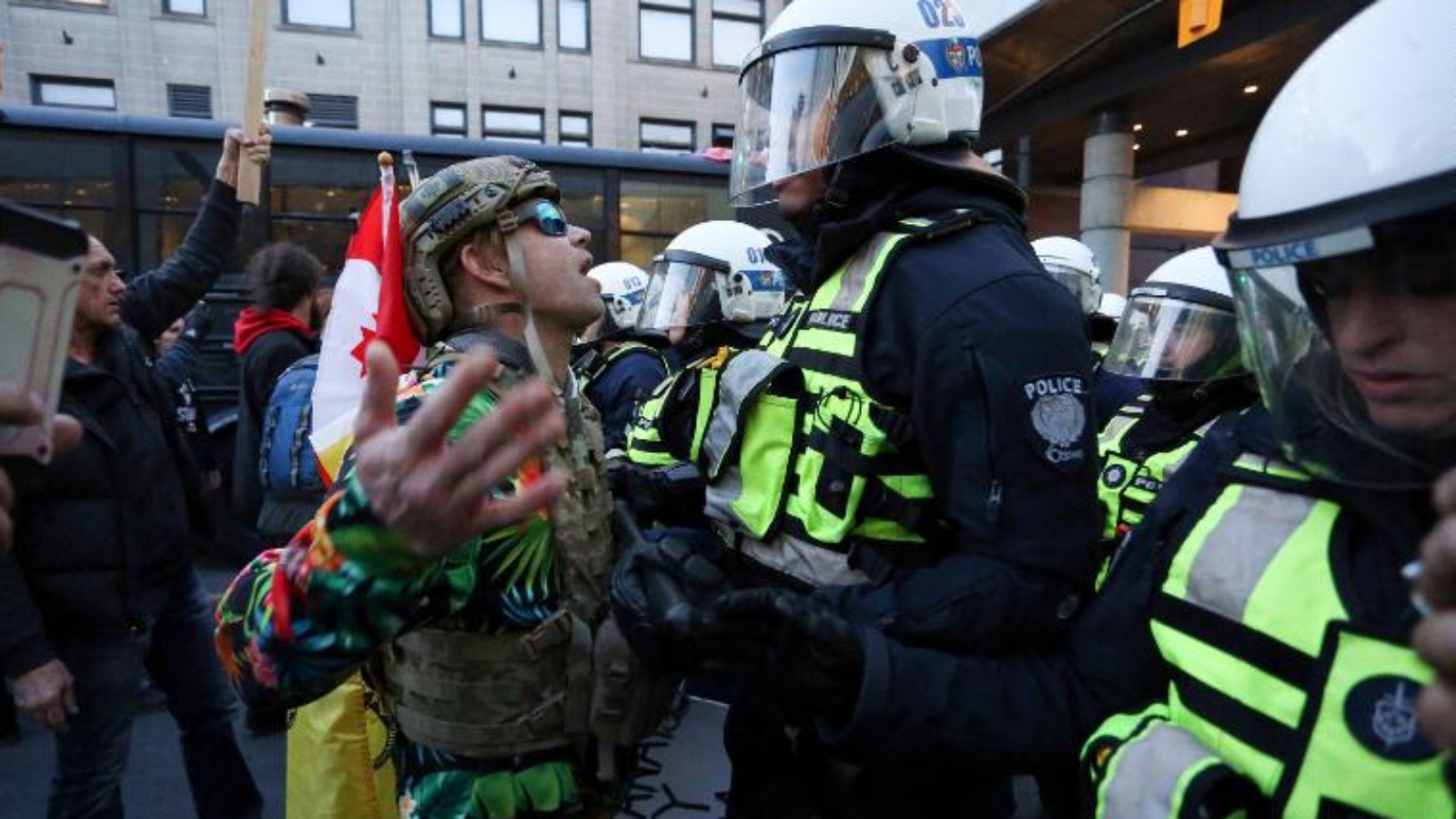 أحد مؤيدي قافلة Rolling Thunder يواجه ضابط شرطة مكافحة الشغب خلال احتجاج يوم الجمعة في أوتاوا، كندا.