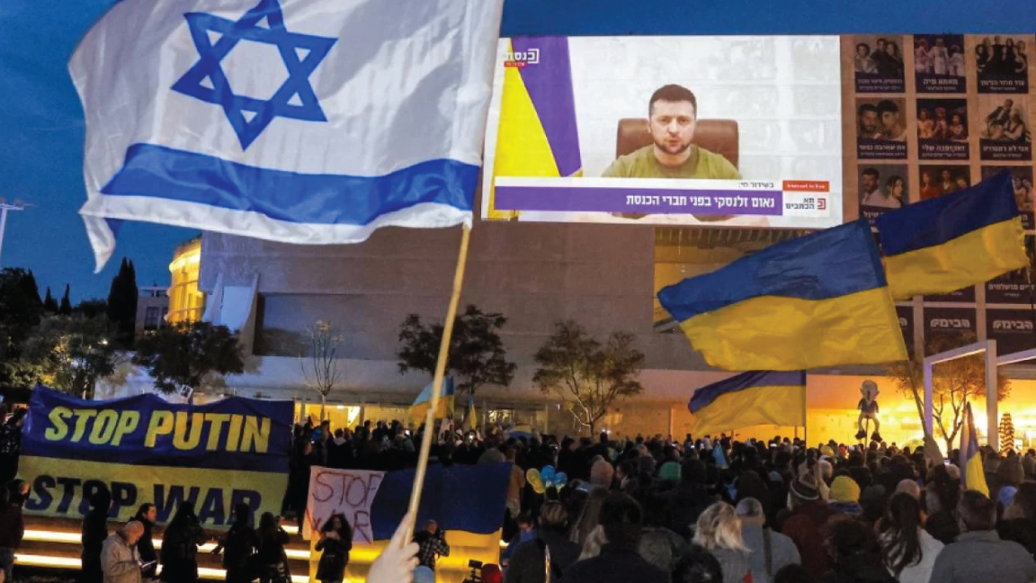 متظاهرون يتجمعون في ساحة حبيمة في وسط تل أبيب لمشاهدة خطاب متلفز بالفيديو للرئيس الأوكراني فولوديمير زيلينسكي في الكنيست الإسرائيلي، في 20 مارس 2022