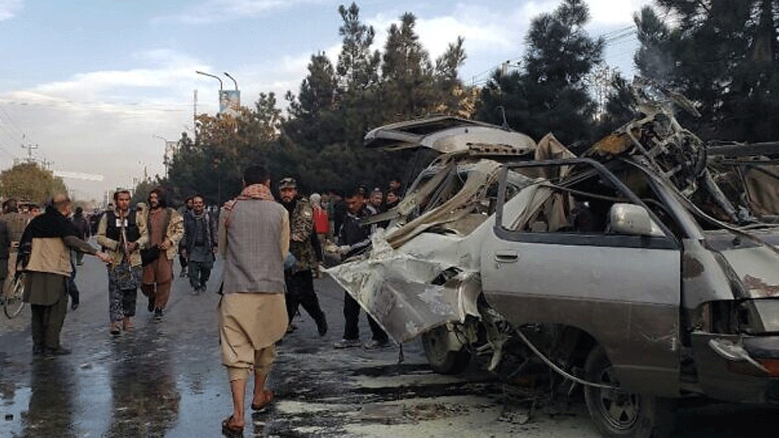 سكان يتجمعون بجوار حافلة صغيرة مدمرة بعد انفجار قنبلة أسفر عن مقتل شخصين وإصابة خمسة آخرين في كابول، في 17 تشرين الثاني\ نوفمبر 2021.
