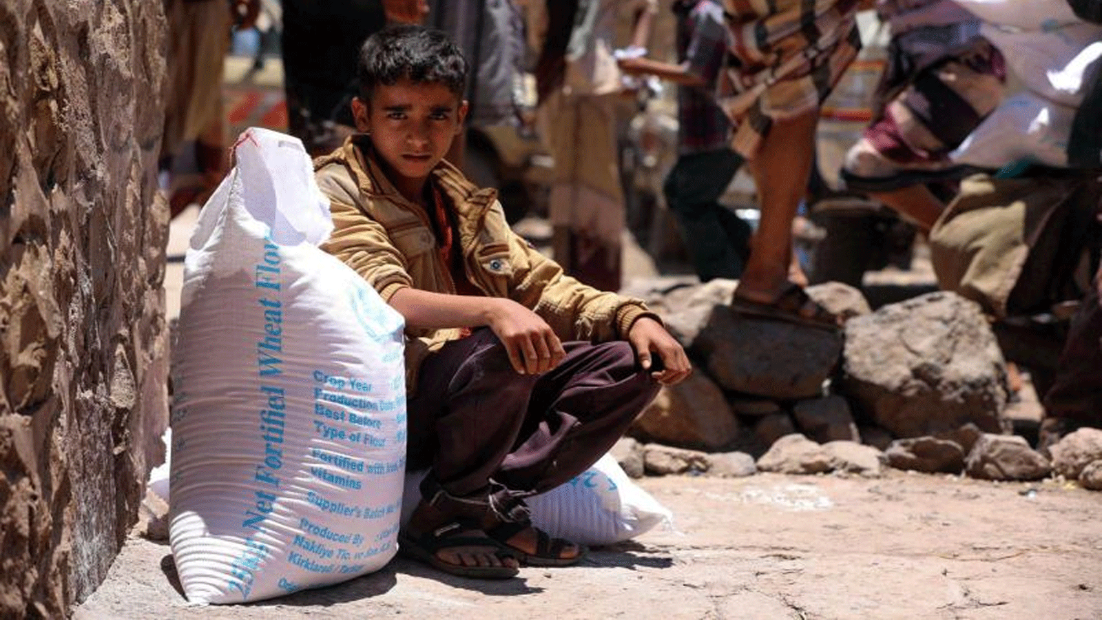 طفل يمني يتلقى مساعدات إنسانية مقدمة من برنامج الغذاء العالمي في مدينة تعز الثالثة في البلاد